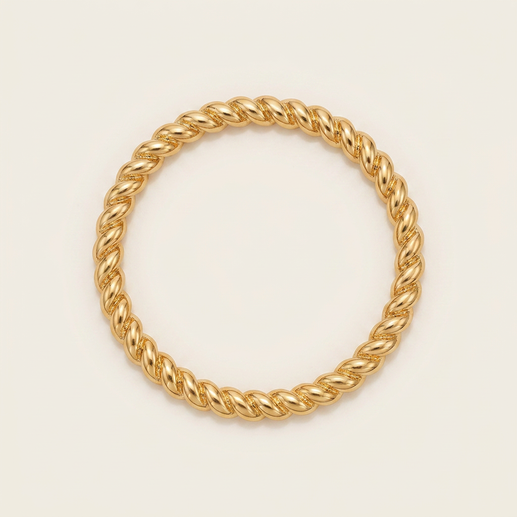 Lisa twisted gold bangle, top-down flat lay on cream